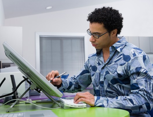 African graphic designer working on computer in office