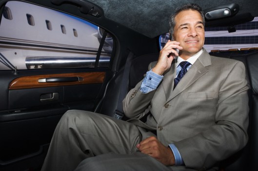 Businessman talking on his cell phone in limo