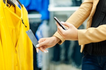 Woman scanning QR code in shopping mall